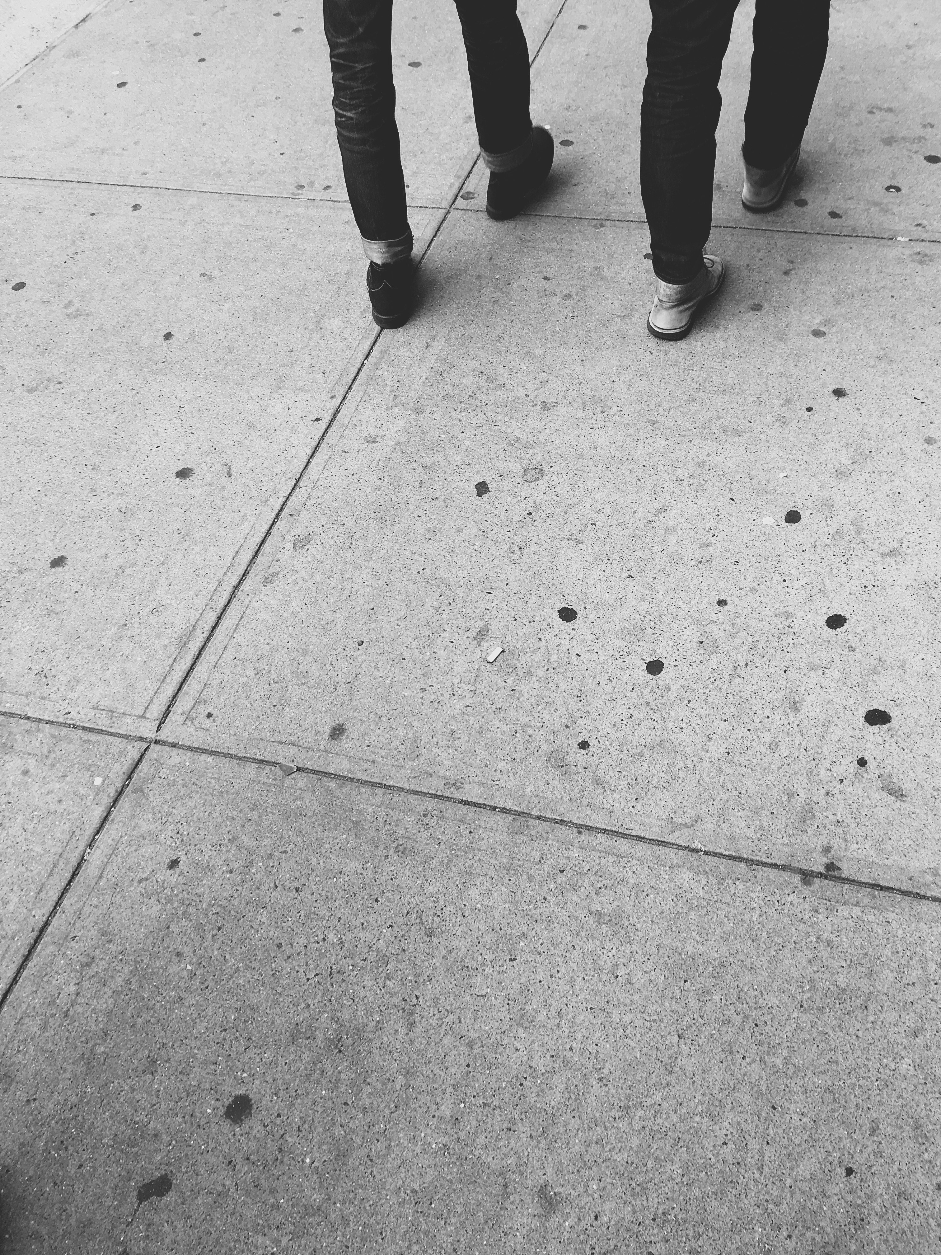 two persons walking on concrete floor